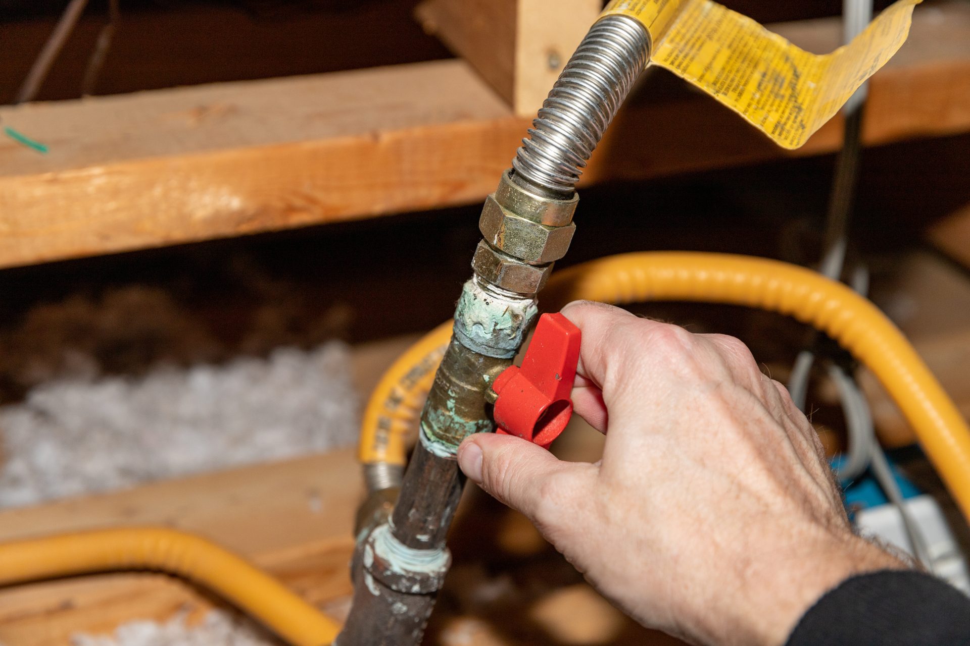 Plumber manually turning off valve on a natural gas pipe