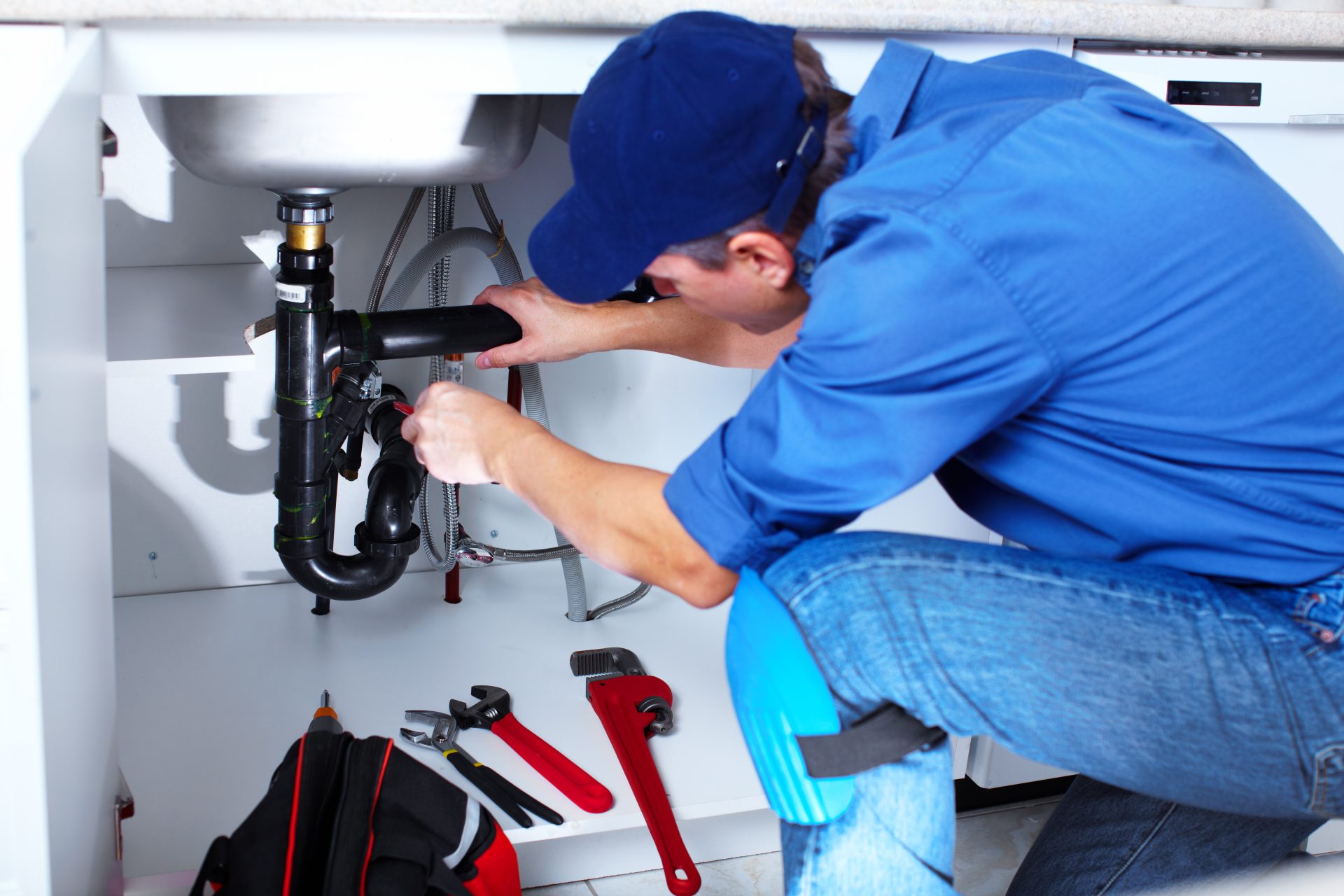 Favored Plumbing & Rooter Services In East Sonora, CA | Avalon Rooter A black faucet is turned on to allow water to flow from it and into a white sink beneath it. In the background, there is a white soap dispenser with a black lid visible.