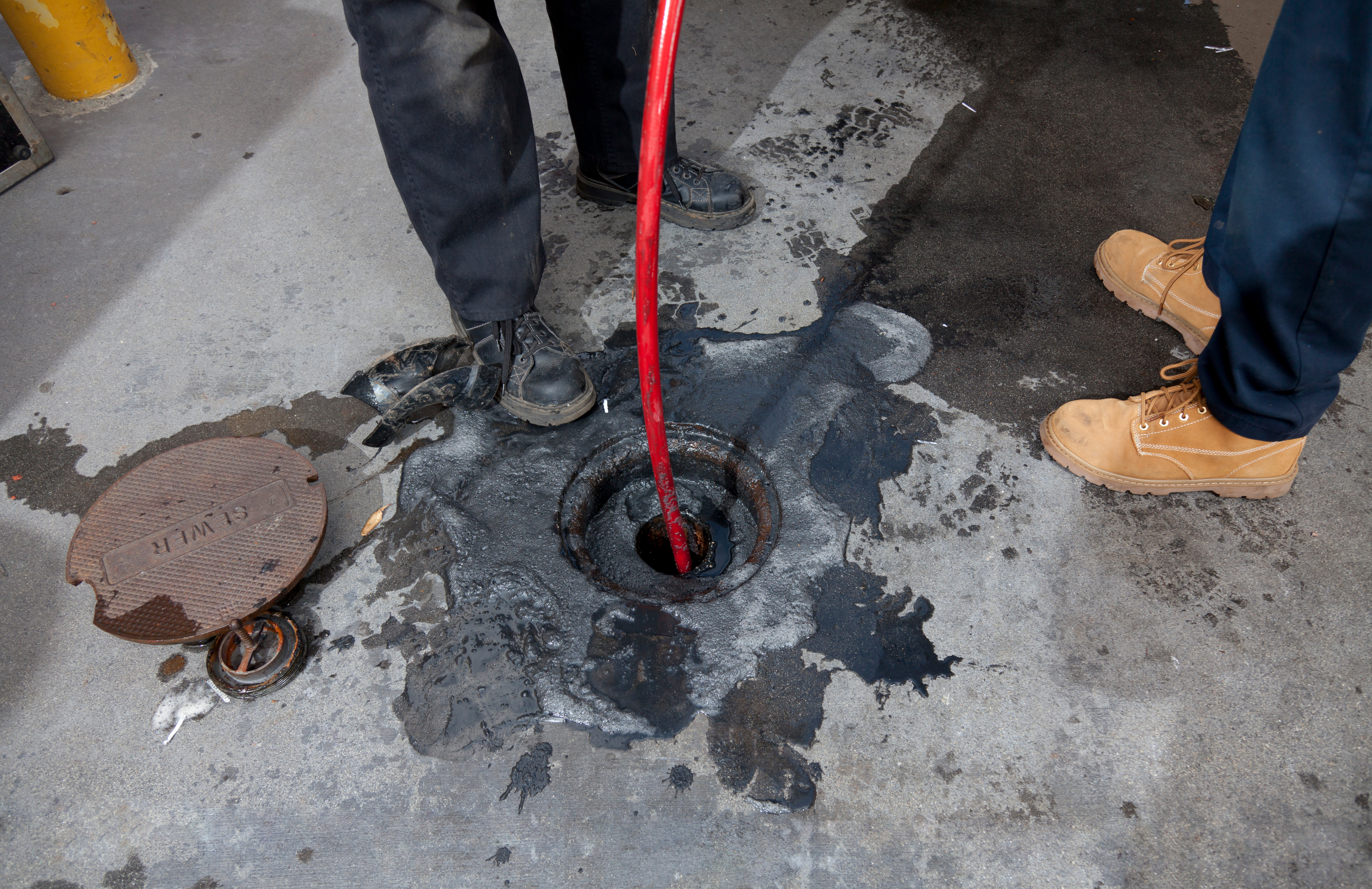 Two Workers Hydro Jetting A Sewer Line