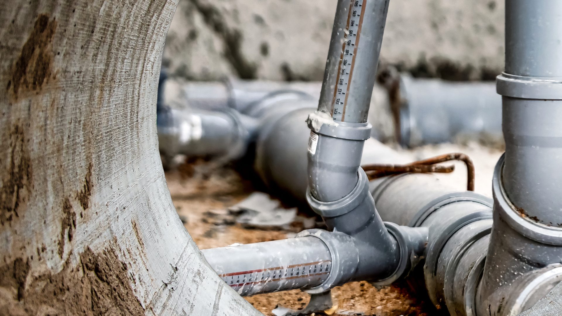 Close-up of inside of a large sewer pipe with smaller connected pipes on the outside