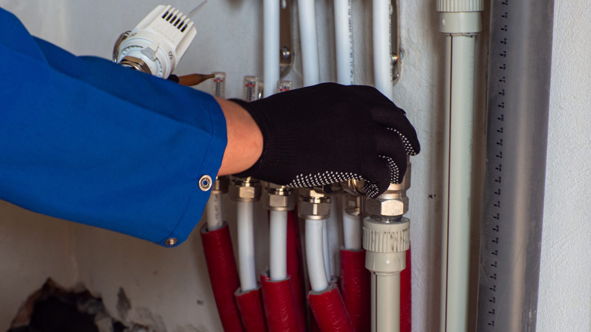 Plumber with his hand on a bundle of gas lines inside