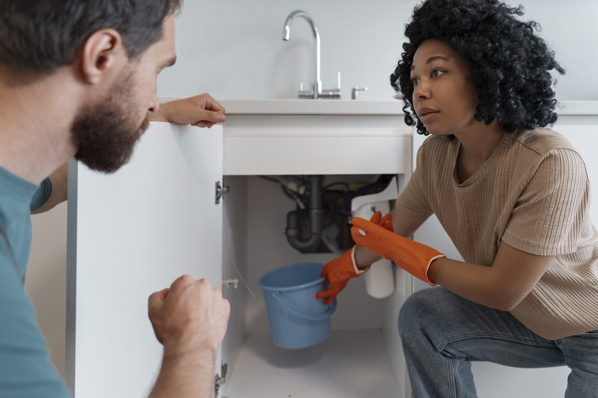 A customer shows the plumber the repair that needs to be done underneath the sink