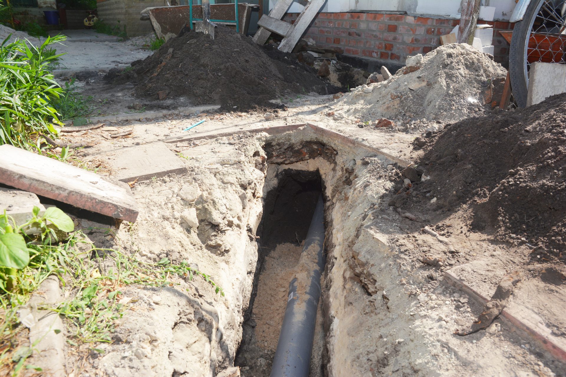 A sewer line replacement in process with the trench dug and the line in place.
