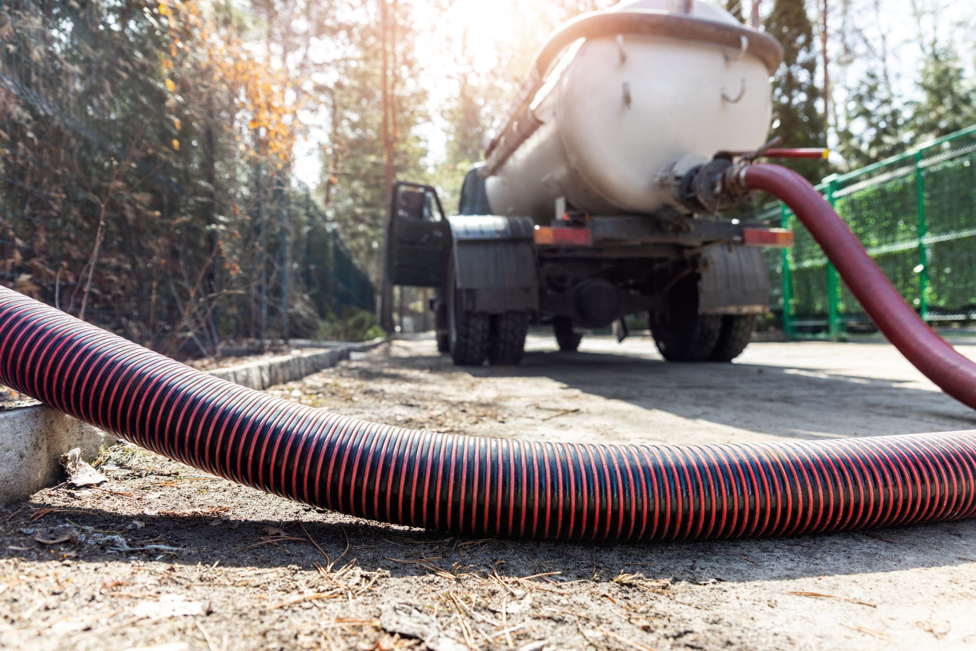 A septic tank truck actively working on a septic tank.