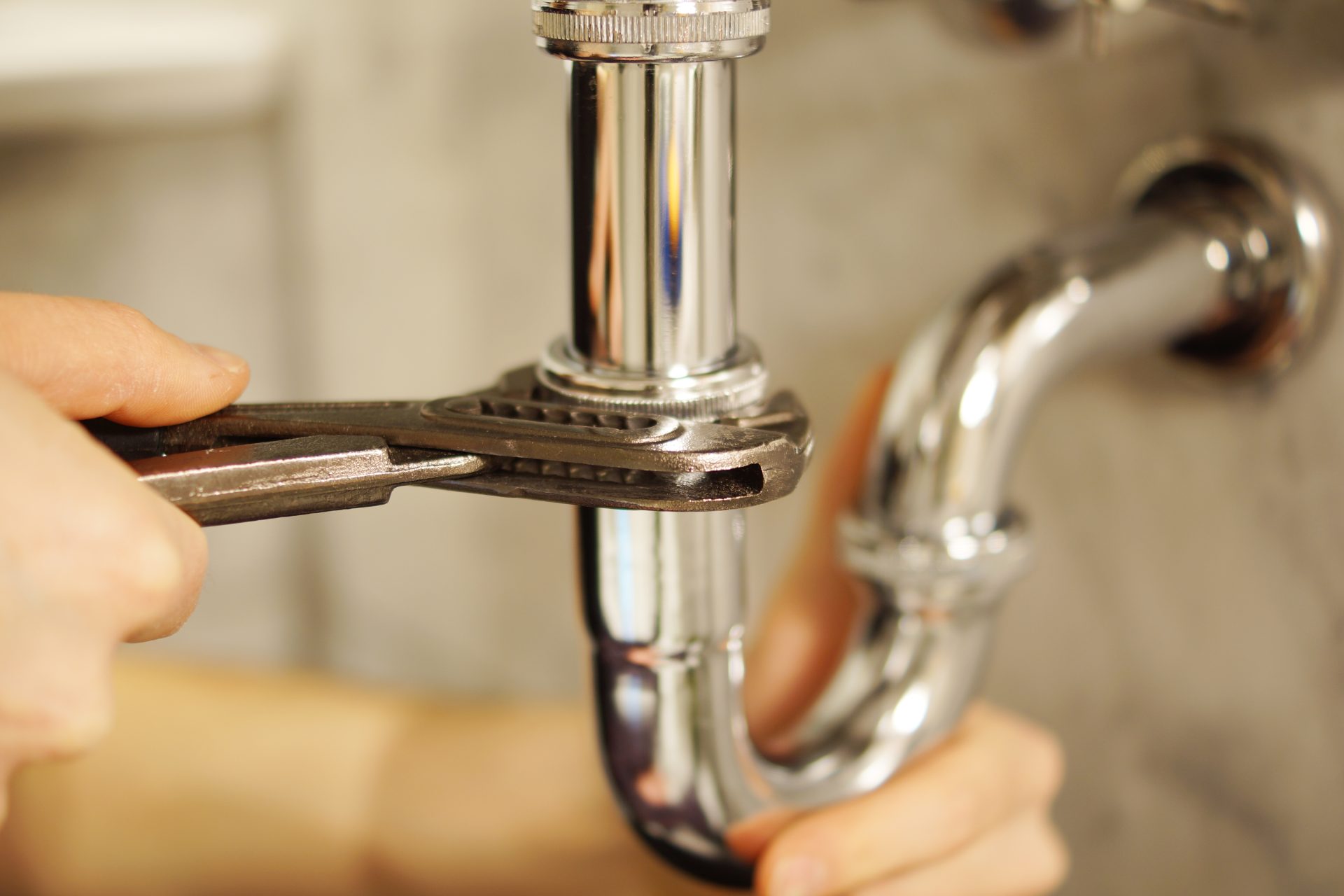 A plumber completes repairs on a sink drain.