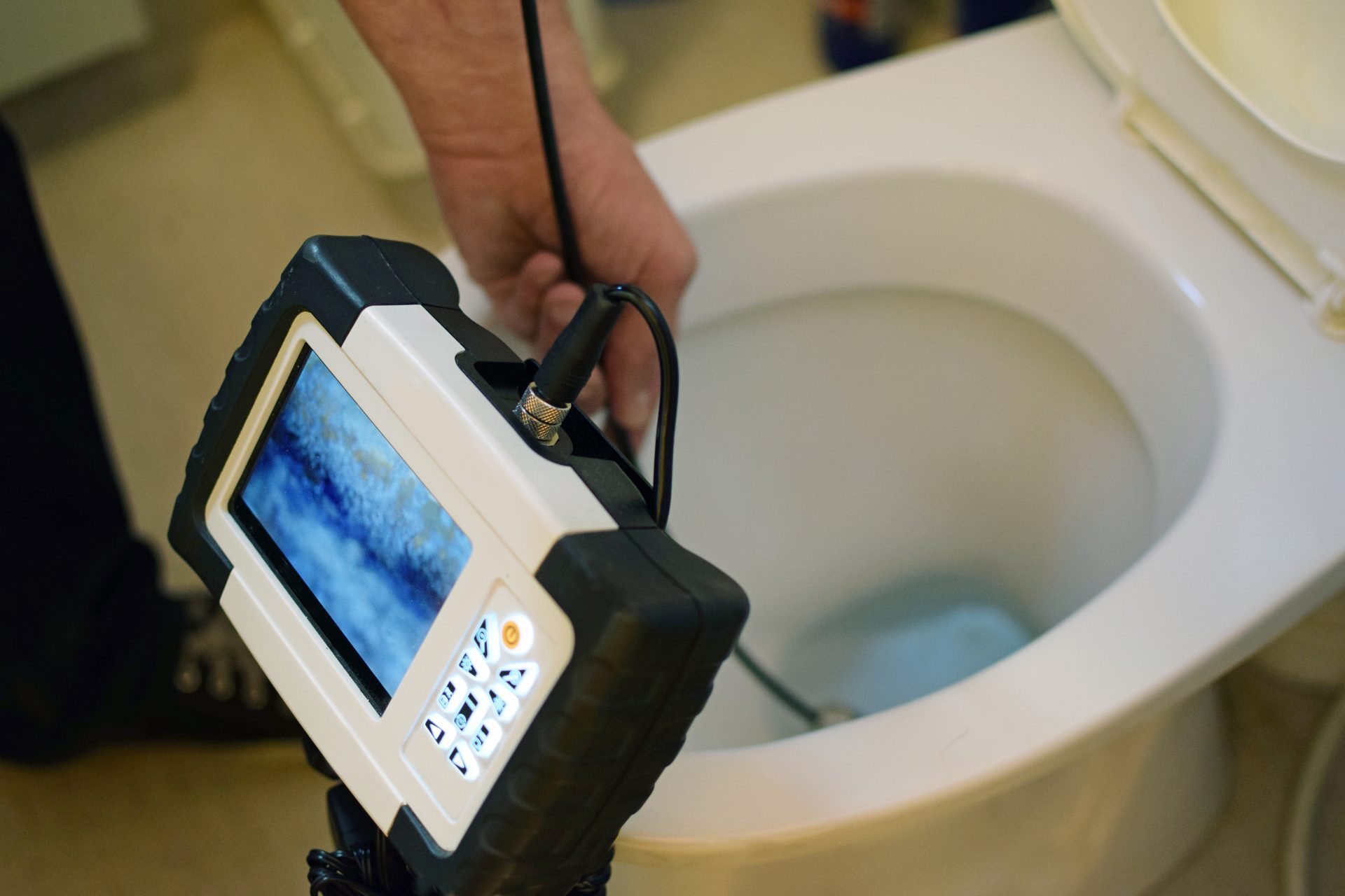 A technician uses a sewer line camera to complete an inspection.