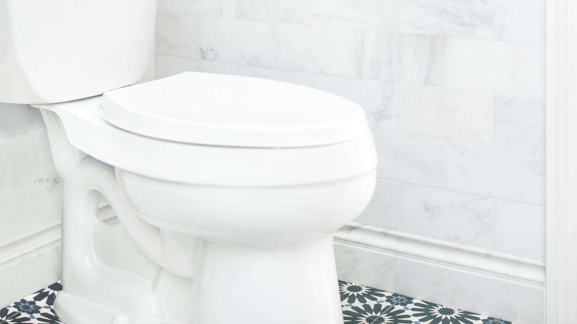A silver faucet with a single handle is dripping water, even though the handle's positon is set to 'off'.